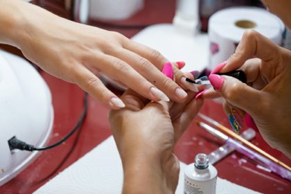 closeup of manicurist doing nail art to a client