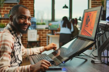 Creative office worker sitting at computer and creating digital art