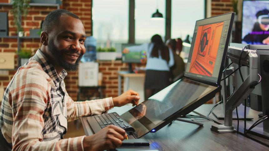 Creative office worker sitting at computer and creating digital art