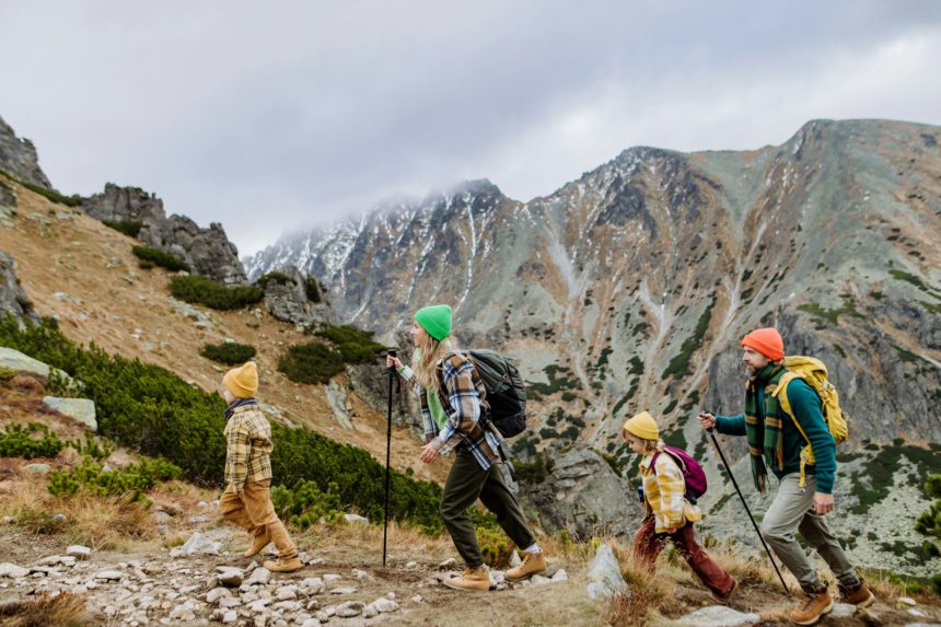 Happy family hiking together in autumn mountains.