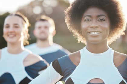 Smile, fitness and a cheerleader group outdoor together for support, motivation or competition in s